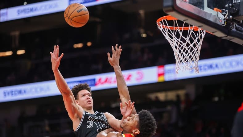 Feb 11, 2023; Atlanta, Georgia, USA; San Antonio Spurs forward Isaiah Roby (18) shoots over Atlanta Hawks forward De'Andre Hunter (12) in the second quarter at State Farm Arena. Mandatory Credit: Brett Davis-USA TODAY Sports