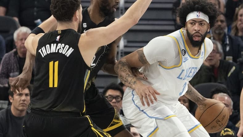 February 11, 2023; San Francisco, California, USA; Los Angeles Lakers forward Anthony Davis (3) dribbles the basketball against Golden State Warriors guard Klay Thompson (11) and forward Andrew Wiggins (22) during the second quarter at Chase Center. Mandatory Credit: Kyle Terada-USA TODAY Sports
