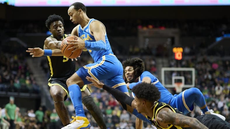 Feb 11, 2023; Eugene, Oregon, USA; UCLA Bruins guard Amari Bailey (5) dribbles the ball during the first half past Oregon Ducks guard Jermaine Couisnard (5) at Matthew Knight Arena. Mandatory Credit: Troy Wayrynen-USA TODAY Sports