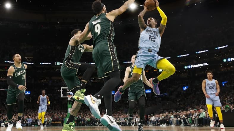 Feb 12, 2023; Boston, Massachusetts, USA; Memphis Grizzlies guard Ja Morant (12) shoots against Boston Celtics guard Derrick White (9) during the second quarter at TD Garden. Mandatory Credit: Winslow Townson-USA TODAY Sports