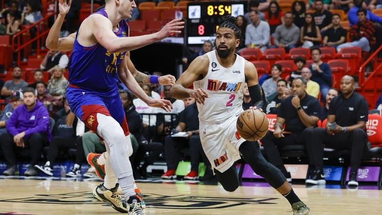 Feb 13, 2023; Miami, Florida, USA; Miami Heat guard Gabe Vincent (2) drives to the basket as Denver Nuggets center Nikola Jokic (15) defends during the first quarter at Miami-Dade Arena. Mandatory Credit: Sam Navarro-USA TODAY Sports