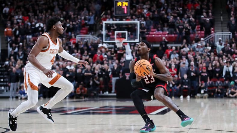 Feb 13, 2023; Lubbock, Texas, USA;  Texas Tech Red Raiders guard De'Vion Harmon (23) stops to shoot against Texas Longhorns guard Tyrese Hunter (4) in the first half at United Supermarkets Arena. Mandatory Credit: Michael C. Johnson-USA TODAY Sports