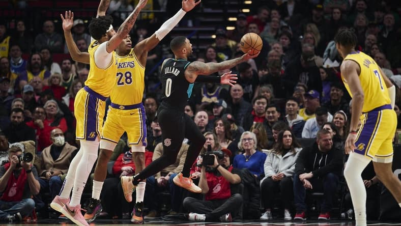 Feb 13, 2023; Portland, Oregon, USA; Portland Trail Blazers guard Damian Lillard (0) drives to the basket during the first half against Los Angeles Lakers forward Anthony Davis (3) and forward Rui Hachimura (28) at Moda Center. Mandatory Credit: Troy Wayrynen-USA TODAY Sports