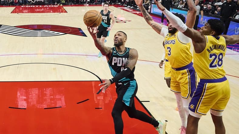 Feb 13, 2023; Portland, Oregon, USA; Portland Trail Blazers guard Damian Lillard (0) drives to the basket during the first half against Los Angeles Lakers forward Anthony Davis (3) and forward Rui Hachimura (28) at Moda Center. Mandatory Credit: Troy Wayrynen-USA TODAY Sports