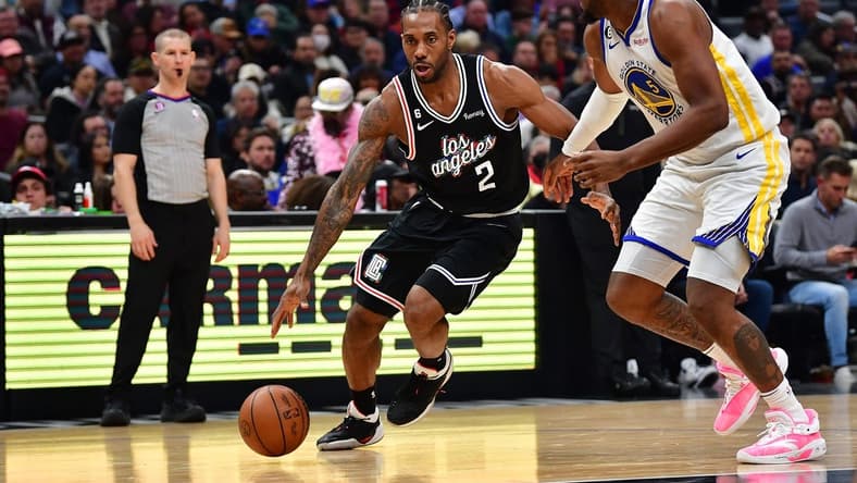 Feb 14, 2023; Los Angeles, California, USA; Los Angeles Clippers forward Kawhi Leonard (2) moves to the basket against Golden State Warriors forward Kevon Looney (5) during the first half at Crypto.com Arena. Mandatory Credit: Gary A. Vasquez-USA TODAY Sports