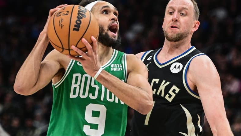 Feb 14, 2023; Milwaukee, Wisconsin, USA;  Boston Celtics guard Derrick White (9) looks for a shot against Milwaukee Bucks forward Joe Ingles (7) in the fourth quarter at Fiserv Forum. Mandatory Credit: Benny Sieu-USA TODAY Sports