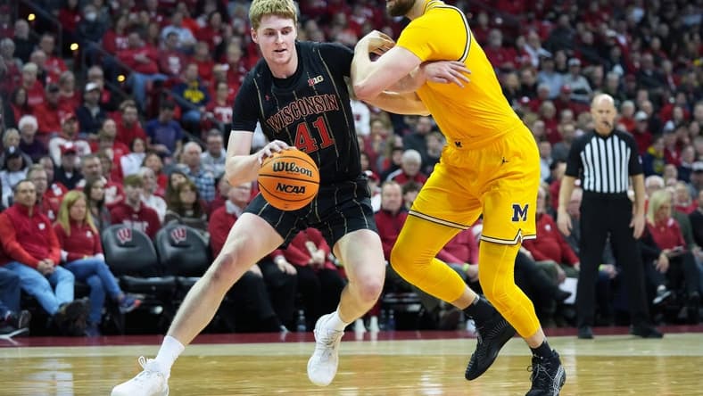 Feb 14, 2023; Madison, Wisconsin, USA; Wisconsin Badgers forward Steven Crowl (41) drives to the basket under coverage by Michigan Wolverines center Hunter Dickinson (1) during the second half at the Kohl Center. Mandatory Credit: Kayla Wolf-USA TODAY Sports