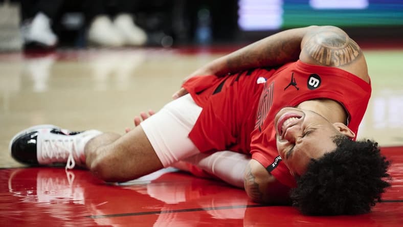 Feb 14, 2023; Portland, Oregon, USA; Portland Trail Blazers guard Anfernee Simons (1) grimaces in pain after injuring himself during the second half against the Washington Wizards at Moda Center. Mandatory Credit: Troy Wayrynen-USA TODAY Sports