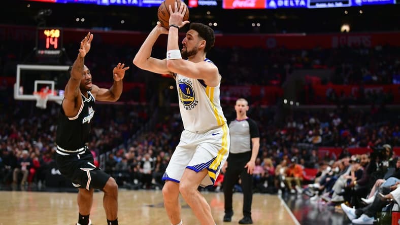 Feb 14, 2023; Los Angeles, California, USA; Golden State Warriors guard Klay Thompson (11) shoots against Los Angeles Clippers forward Kawhi Leonard (2) during the second half at Crypto.com Arena. Mandatory Credit: Gary A. Vasquez-USA TODAY Sports