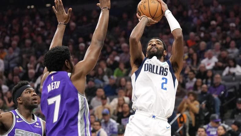 Feb 11, 2023; Sacramento, California, USA; Dallas Mavericks guard Kyrie Irving (2) shoots against Sacramento Kings forward Chimezie Metu (7) during the second quarter at Golden 1 Center. Mandatory Credit: Darren Yamashita-USA TODAY Sports