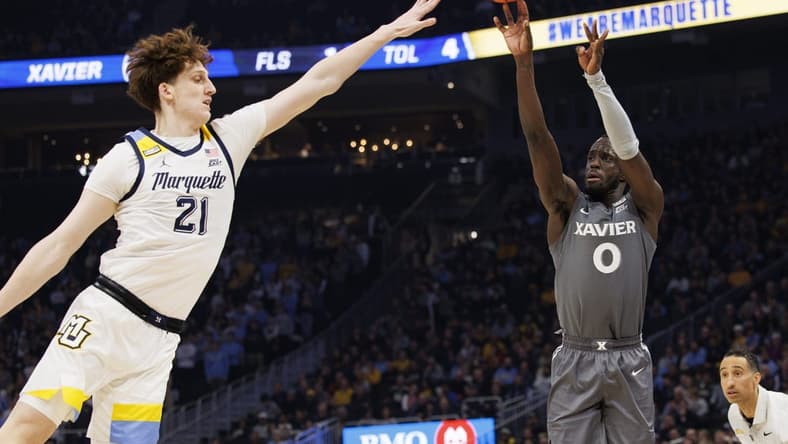 Feb 15, 2023; Milwaukee, Wisconsin, USA; Xavier Musketeers guard Souley Boum (0) shoots against Marquette Golden Eagles forward Ben Gold (21) during the first half at Fiserv Forum. Mandatory Credit: Jeff Hanisch-USA TODAY Sports