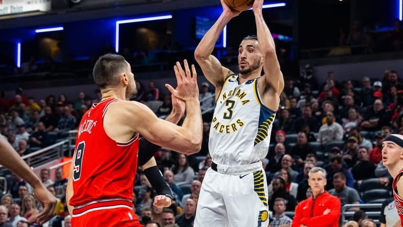 Feb 15, 2023; Indianapolis, Indiana, USA; Indiana Pacers guard Chris Duarte (3) passes the ball while Chicago Bulls center Nikola Vucevic (9) defends in the second quarter at Gainbridge Fieldhouse. Mandatory Credit: Trevor Ruszkowski-USA TODAY Sports