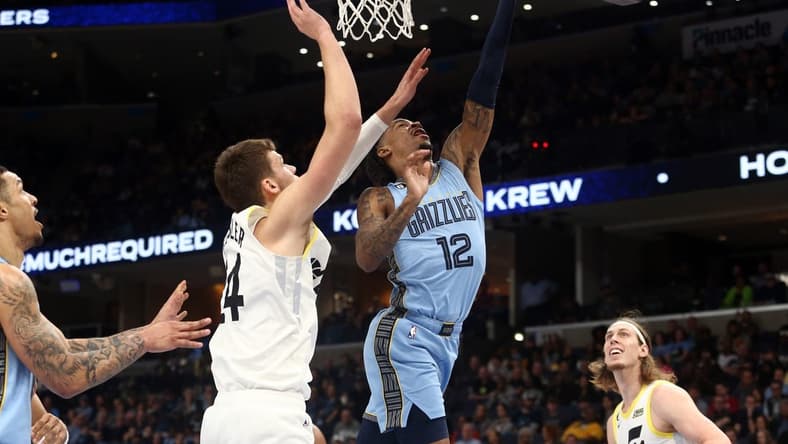 Feb 15, 2023; Memphis, Tennessee, USA; Memphis Grizzlies guard Ja Morant (12) shoots as Utah Jazz center Walker Kessler (24) defends during the first half at FedExForum. Mandatory Credit: Petre Thomas-USA TODAY Sports
