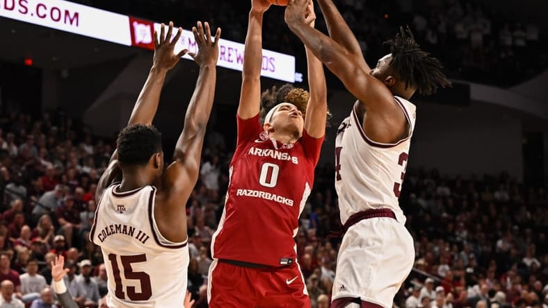 Feb 15, 2023; College Station, Texas, USA;Arkansas Razorbacks guard Anthony Black (0) looks to shoot over Texas A&M Aggies forward Henry Coleman III (15) and forward Julius Marble (34) during the first half at Reed Arena. Mandatory Credit: Maria Lysaker-USA TODAY Sports