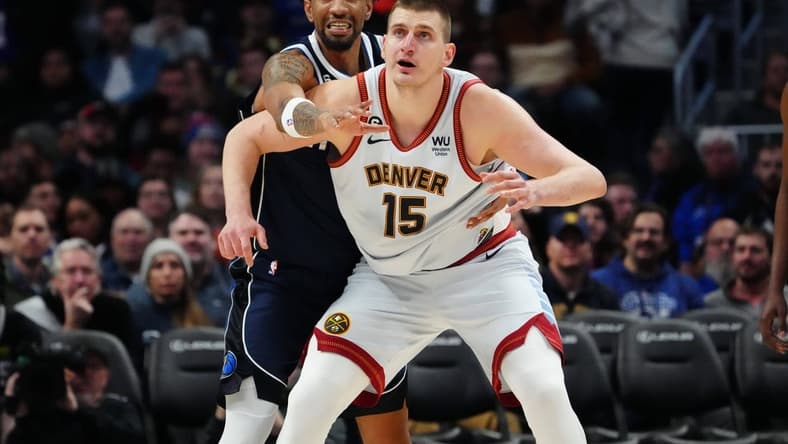Feb 15, 2023; Denver, Colorado, USA; Dallas Mavericks forward Christian Wood (35) reaches over Denver Nuggets center Nikola Jokic (15) in the second half at Ball Arena. Mandatory Credit: Ron Chenoy-USA TODAY Sports