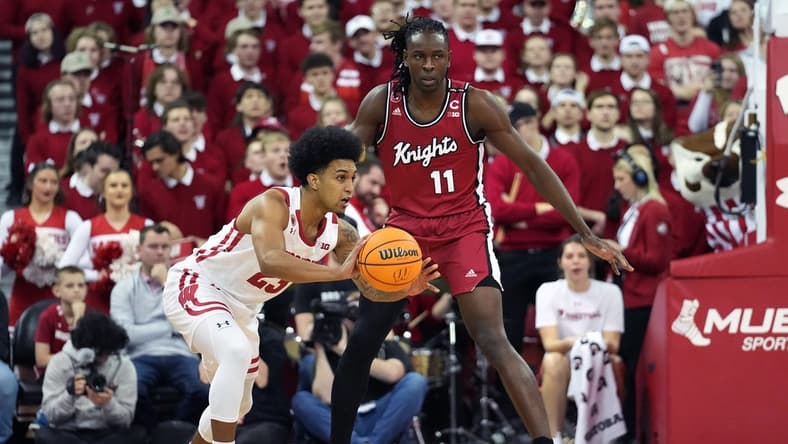 Feb 18, 2023; Madison, Wisconsin, USA; Wisconsin Badgers guard Chucky Hepburn (23) passes against Rutgers Scarlet Knights center Clifford Omoruyi (11) during the first half at the Kohl Center. Mandatory Credit: Kayla Wolf-USA TODAY Sports