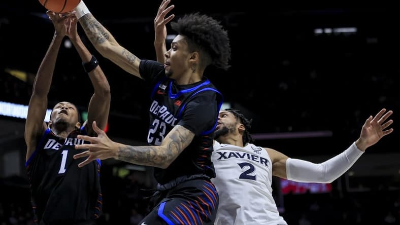 Feb 18, 2023; Cincinnati, Ohio, USA; DePaul Blue Demons guard Caleb Murphy (middle), forward Javan Johnson (left), and Xavier Musketeers forward Jerome Hunter battle for a rebound in the first half at the Cintas Center. Mandatory Credit: Aaron Doster-USA TODAY Sports