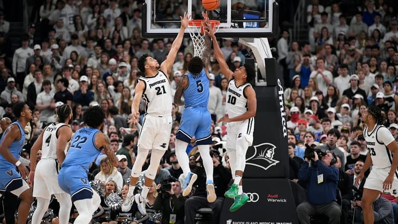 Feb 18, 2023; Providence, Rhode Island, USA; Providence Friars forward Clifton Moore (21) and Providence Friars guard Noah Locke (10) defend the basket from Villanova Wildcats guard Justin Moore (5) during the first half at Amica Mutual Pavilion. Mandatory Credit: Eric Canha-USA TODAY Sports