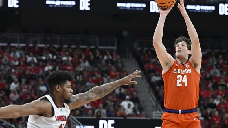 Feb 18, 2023; Louisville, Kentucky, USA; Clemson Tigers center PJ Hall (24) shoots against Louisville Cardinals forward Sydney Curry (21) during the first half at KFC Yum! Center. Mandatory Credit: Jamie Rhodes-USA TODAY Sports