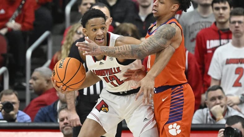 Feb 18, 2023; Louisville, Kentucky, USA; Louisville Cardinals forward JJ Traynor (12) posts up against Clemson Tigers guard Brevin Galloway (11) during the first half at KFC Yum! Center. Mandatory Credit: Jamie Rhodes-USA TODAY Sports