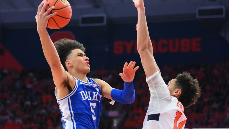 Feb 18, 2023; Syracuse, New York, USA; Duke Blue Devils guard Tyrese Proctor (5) shoots the ball against Syracuse Orange center Jesse Edwards (14) during the second half at the JMA Wireless Dome. Mandatory Credit: Rich Barnes-USA TODAY Sports
