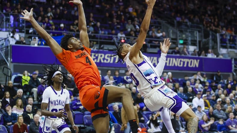 Feb 18, 2023; Seattle, Washington, USA; Washington Huskies guard Koren Johnson (0) puts up a shot following a foul by Oregon State Beavers guard Dexter Akanno (4) during the first half at Alaska Airlines Arena at Hec Edmundson Pavilion. Mandatory Credit: Joe Nicholson-USA TODAY Sports