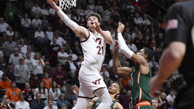 Feb 21, 2023; Blacksburg, Virginia, USA; Virginia Tech Hokies forward Grant Basile (21) drives to basket past Miami (Fl) Hurricanes forward A.J. Casey (0) in the second half at Cassell Coliseum. Mandatory Credit: Lee Luther Jr.-USA TODAY Sports