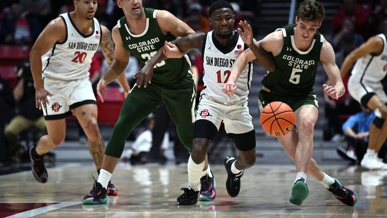 Feb 21, 2023; San Diego, California, USA; San Diego State Aztecs guard Darrion Trammell (12) and Colorado State Rams guard Baylor Hebb (5) battle for a loose ball during the first half at Viejas Arena. Mandatory Credit: Orlando Ramirez-USA TODAY Sports