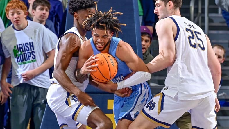 Feb 22, 2023; South Bend, Indiana, USA; North Carolina Tar Heels guard RJ Davis (4) is fouled by Notre Dame Fighting Irish forward Matt Zona (25) during the first half at the Purcell Pavilion. Mandatory Credit: Matt Cashore-USA TODAY Sports