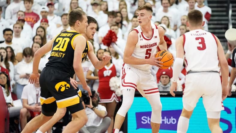 Feb 22, 2023; Madison, Wisconsin, USA; Wisconsin Badgers forward Tyler Wahl (5) looks to pass under coverage by Iowa Hawkeyes forward Payton Sandfort (20) and forward Filip Rebraca (0) during the first half at the Kohl Center. Mandatory Credit: Kayla Wolf-USA TODAY Sports