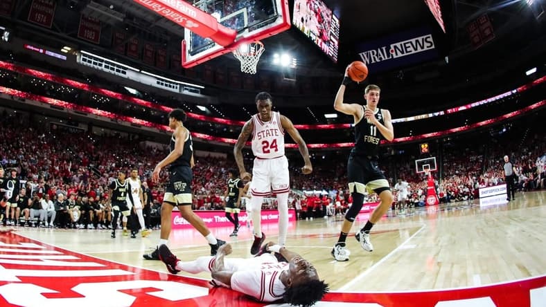 Feb 22, 2023; Raleigh, North Carolina, USA; North Carolina State Wolfpack guard Jarkel Joiner (1) scores and celebrates on the floor with forward Ernest Ross (24) as Wake Forest Demon Deacons forward Andrew Carr (11) looks on during the first half against Wake Forest Demon Deacons at PNC Arena. Mandatory Credit: Jaylynn Nash-USA TODAY Sports