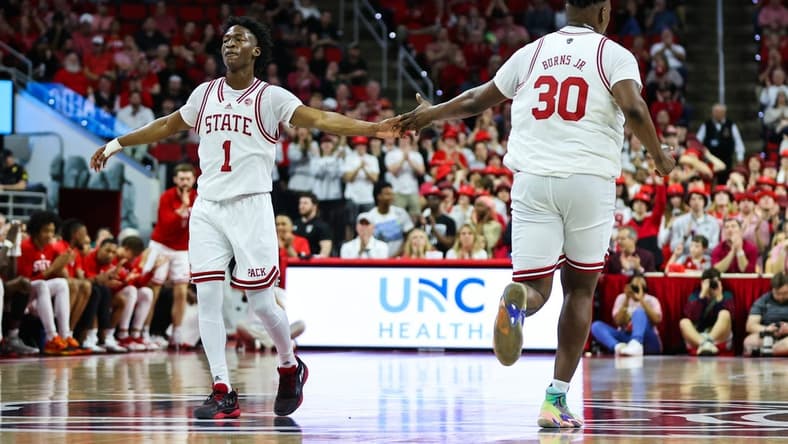 Feb 22, 2023; Raleigh, North Carolina, USA; North Carolina State Wolfpack forward D.J. Burns Jr. (30) and guard Jarkel Joiner (1) celebrate during the first half against Wake Forest Demon Deacons at PNC Arena. Mandatory Credit: Jaylynn Nash-USA TODAY Sports