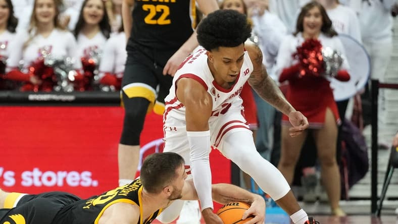 Feb 22, 2023; Madison, Wisconsin, USA; Wisconsin Badgers guard Chucky Hepburn (23) and Iowa Hawkeyes guard Connor McCaffery (30) go after a loose ball during the second half at the Kohl Center. Mandatory Credit: Kayla Wolf-USA TODAY Sports
