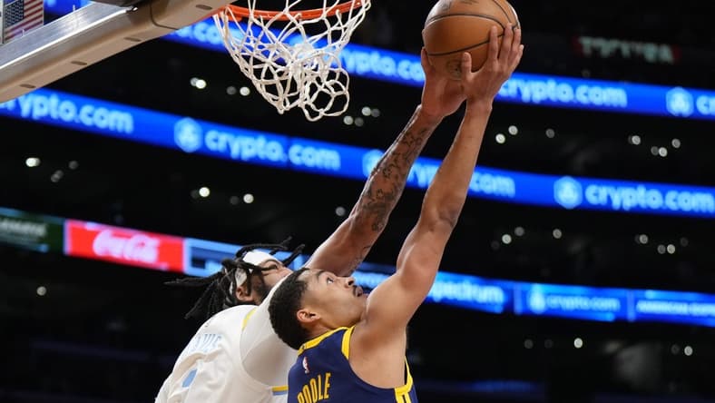Feb 23, 2023; Los Angeles, California, USA; Golden State Warriors guard Jordan Poole (left) drives to the net against Los Angeles Lakers forward Anthony Davis in the first half at Crypto.com Arena. Mandatory Credit: Kirby Lee-USA TODAY Sports