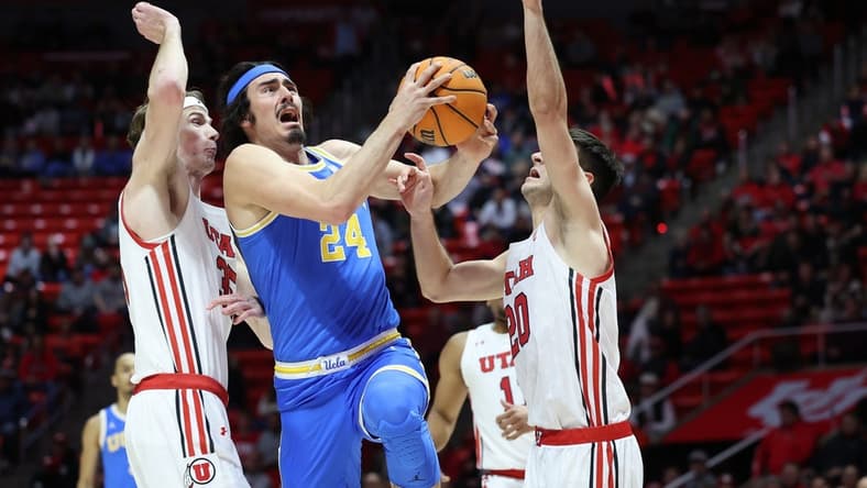 Feb 23, 2023; Salt Lake City, Utah, USA; UCLA Bruins guard Jaime Jaquez Jr. (24) drives between Utah Utes center Branden Carlson (35) and guard Lazar Stefanovic (20) in the first half at Jon M. Huntsman Center. Mandatory Credit: Rob Gray-USA TODAY Sports