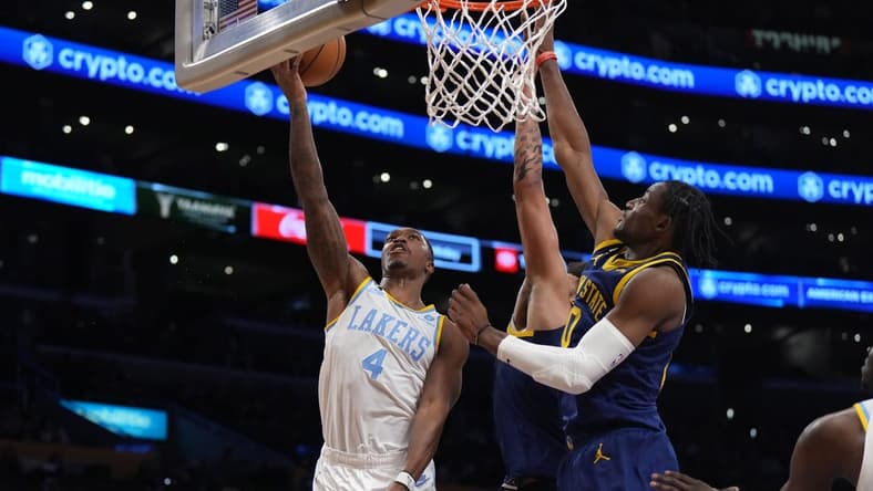 Feb 23, 2023; Los Angeles, California, USA; Los Angeles Lakers guard Lonnie Walker IV (4) shoots the ball against Golden State Warriors forward Anthony Lamb (40) and forward Jonathan Kuminga (00) in the second half at Crypto.com Arena. Mandatory Credit: Kirby Lee-USA TODAY Sports