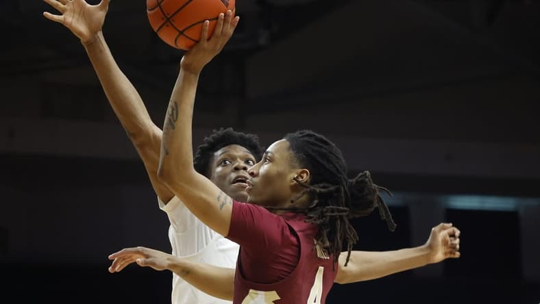 Feb 25, 2023; Coral Gables, Florida, USA; Florida State Seminoles guard Caleb Mills (4) shoots over Miami Hurricanes guard forward Anthony Walker (1) during the first half at Watsco Center. Mandatory Credit: Rhona Wise-USA TODAY Sports