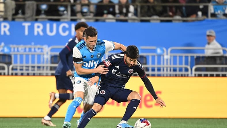 Feb 25, 2023; Charlotte, North Carolina, USA; Charlotte FC midfielder Brandt Bronico (13) and New England Revolution midfielder Carles Gil (10) fight for the ball in the first half at Bank of America Stadium. Mandatory Credit: Bob Donnan-USA TODAY Sports