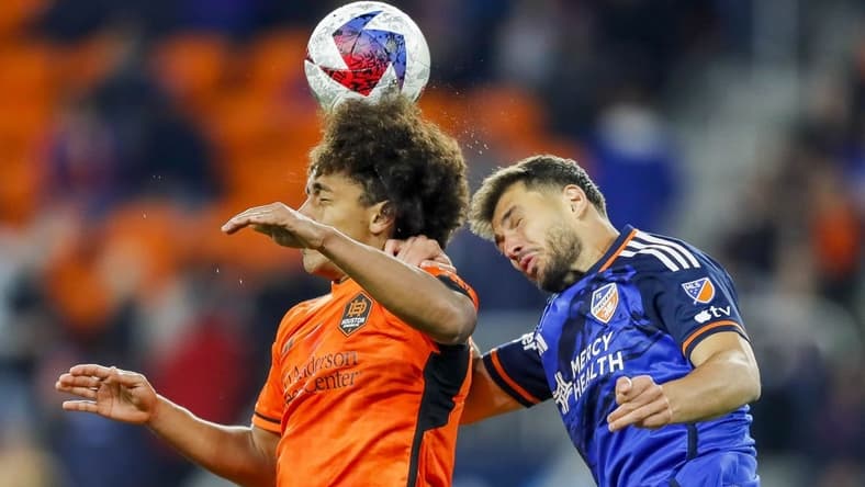 Feb 25, 2023; Cincinnati, Ohio, USA; Houston Dynamo FC midfielder Adalberto Carrasquilla (20) heads the ball against FC Cincinnati defender Matt Miazga (21) in the second half at TQL Stadium. Mandatory Credit: Katie Stratman-USA TODAY Sports