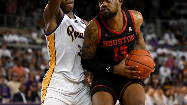 Feb 25, 2023; Greenville, North Carolina, USA;  Houston Cougars forward J'Wan Roberts (13) drives against East Carolina Pirates forward Ezra Ausar (2) during the first half at Williams Arena at Minges Coliseum. Mandatory Credit: William Howard-USA TODAY Sports