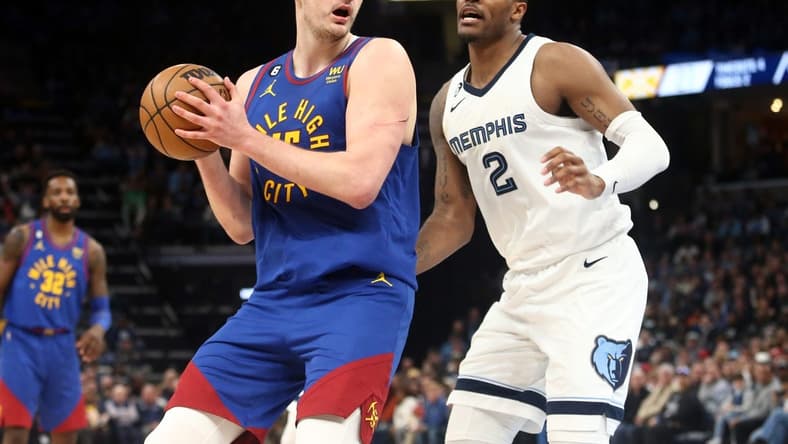 Feb 25, 2023; Memphis, Tennessee, USA; Denver Nuggets center Nikola Jokic (15) spins toward the basket as Memphis Grizzlies forward Xavier Tillman (2) defends during the first half at FedExForum. Mandatory Credit: Petre Thomas-USA TODAY Sports