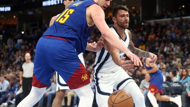 Feb 25, 2023; Memphis, Tennessee, USA; Denver Nuggets center Nikola Jokic (15) and Memphis Grizzlies guard John Konchar (46) battle for a loose ball during the first half at FedExForum. Mandatory Credit: Petre Thomas-USA TODAY Sports