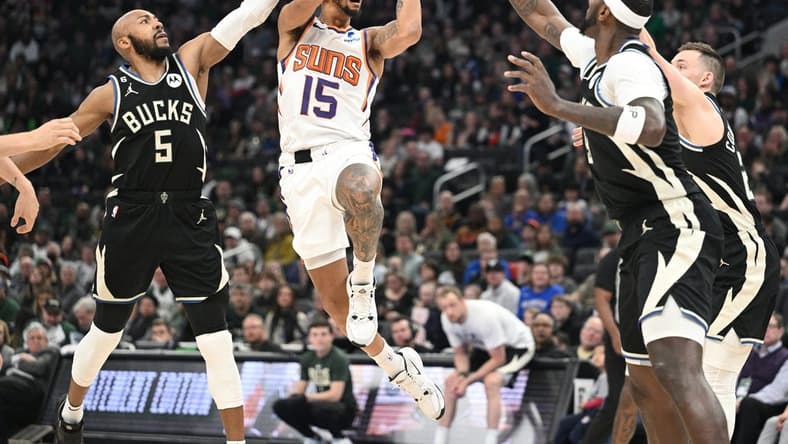 Feb 26, 2023; Milwaukee, Wisconsin, USA; Phoenix Suns guard Cameron Payne (15) puts up a shot against Milwaukee Bucks guard Jevon Carter (5) in the first half at Fiserv Forum. Mandatory Credit: Michael McLoone-USA TODAY Sports