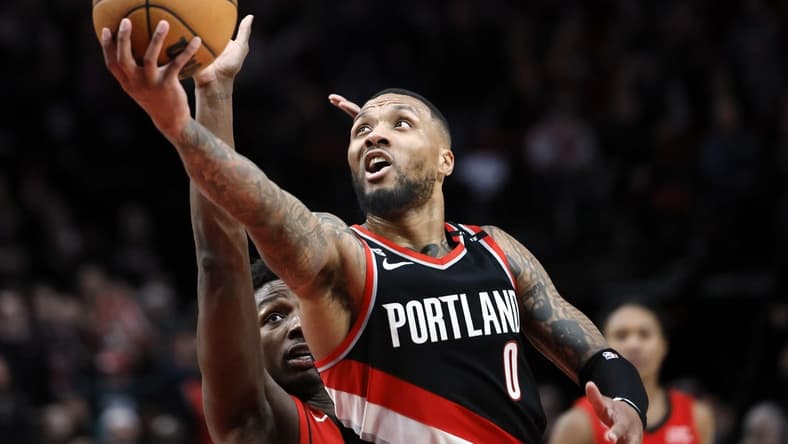 Feb 26, 2023; Portland, Oregon, USA; Portland Trail Blazers point guard Damian Lillard (0) shoots the ball past Houston Rockets small forward Jae'Sean Tate (8, left) during the second half at Moda Center. Mandatory Credit: Soobum Im-USA TODAY Sports