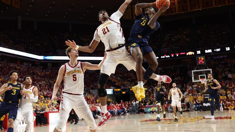 Feb 27, 2023; Ames, Iowa, USA; Iowa State Cyclones center Osun Osunniyi (21) defends the shot from West Virginia Mountaineers guard Kedrian Johnson (0) during the first half at James H. Hilton Coliseum. Mandatory Credit: Reese Strickland-USA TODAY Sports