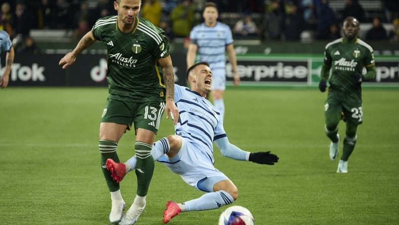 Feb 27, 2023; Portland, Oregon, USA; Sporting Kansas City midfielder Erik Thommy (26) runs into Portland Timbers defender Dario Zuparic (13) during the first half at Providence Park. Mandatory Credit: Troy Wayrynen-USA TODAY Sports
