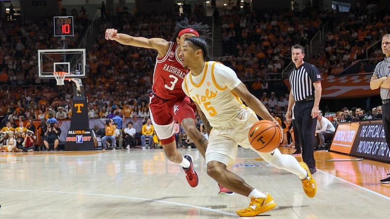 Feb 28, 2023; Knoxville, Tennessee, USA; Tennessee Volunteers guard Zakai Zeigler (5) moves the ball against Arkansas Razorbacks guard Nick Smith Jr. (3) during the first half at Thompson-Boling Arena. Mandatory Credit: Randy Sartin-USA TODAY Sports