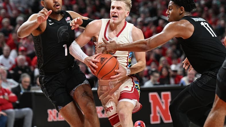 Feb 28, 2023; Lincoln, Nebraska, USA; Nebraska Cornhuskers guard Sam Griesel (5) drives between Michigan State Spartans guard Pierre Brooks (1) and guard A.J. Hoggard (11) in the first half at Pinnacle Bank Arena. Mandatory Credit: Steven Branscombe-USA TODAY Sports