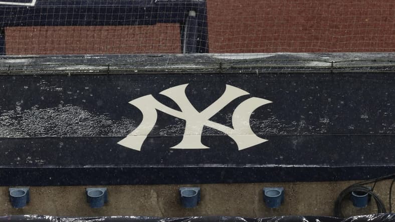 Aug 17, 2020; Bronx, New York, USA; A general view of rain falling on the New York Yankees logo on the first base dugout roof during a rain delay in the game between the New York Yankees and the Boston Red Sox. Mandatory Credit: Vincent Carchietta-USA TODAY Sports