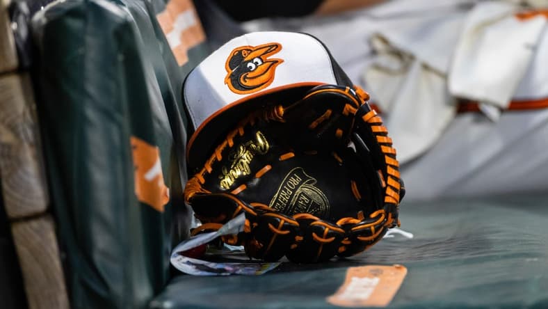 Jun 1, 2021; Baltimore, Maryland, USA; A Baltimore Orioles hat and glove are seen in the dugout during the fourth inning of the game between the Baltimore Orioles and the Minnesota Twins at Oriole Park at Camden Yards. Mandatory Credit: Scott Taetsch-USA TODAY Sports